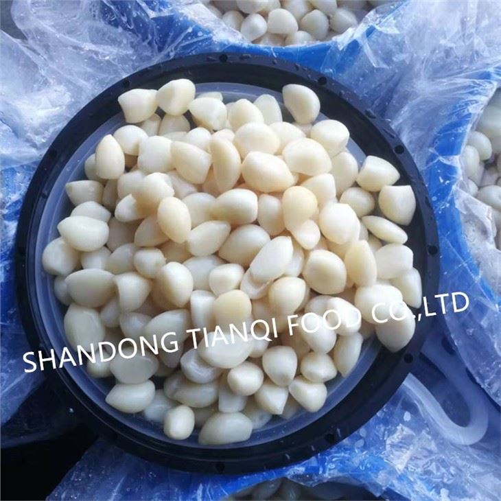 Peeled white garlic cloves in brine in drums